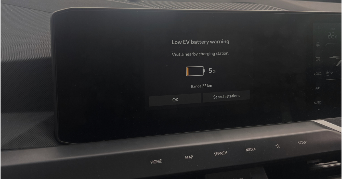 Dashboard screen showing low EV battery warning at 5% during road trip.